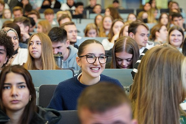 Eine glückliche Studentin im vollen Hörsaal